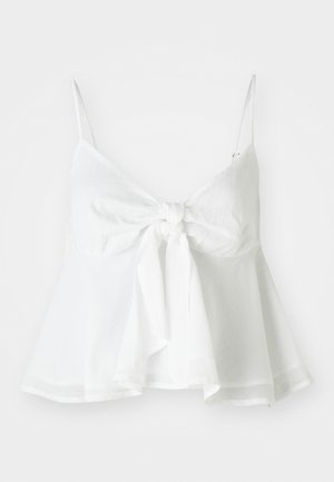 Fehér len crop top, állítható pántokkal és elől megkötős záródással. Bustform és közepes méretű bojt hajtás jellemzi a laza illeszkedés érdekében.