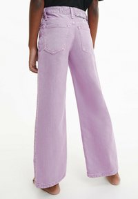 Jeans a gamba larga di colore viola chiaro con un classico design a cinque tasche e una vita alta. Presentano cuciture minimal e una texture liscia.