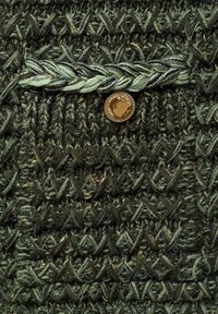 Tissu tricoté vert foncé avec des motifs texturés. Comprend une petite poche, un accent tressé et un détail de bouton rond doré.