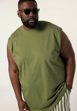 Olijfgroene mouwloze shirt met een relaxte pasvorm, gemaakt van katoen, met een ronde halslijn en een soepele textuur. Gestreepte broek zichtbaar.