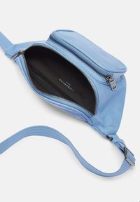 Helleblaue Umhängetasche mit einem Reißverschlussfach und einem verstellbaren Tragegurt. Glatte Textur mit schwarer Innenauskleidung und silbernen Beschlägen.