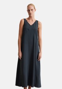 Robe sans manches, longue, de couleur gris foncé avec un décolleté en V, fabriquée dans un tissu lisse. Présente une coupe ample et des coutures subtiles pour un design épuré.