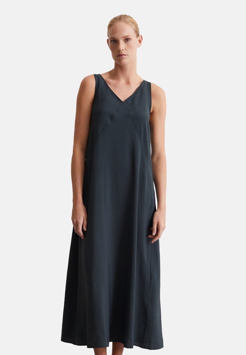 Robe sans manches, longue, de couleur gris foncé avec un décolleté en V, fabriquée dans un tissu lisse. Présente une coupe ample et des coutures subtiles pour un design épuré.