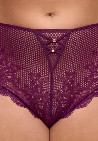 Zbliżenie na środkową część ciała w fioletowej koronkowej i siateczkowej bieliźnie z małymi dekoracyjnymi kokardkami na przednim pasku w talii.