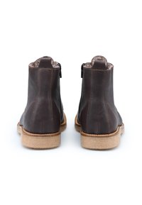 Bruine leren enkelboots met een gladde afwerking, een rits aan de achterkant en rubberen zolen. Ronde neus en textielen voering. Platte uitstraling.