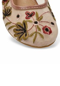 Zapato plano bordado en tela beige. Diseños florales en rojo, verde y negro. Punta redonda con un ribete de cuero liso marrón claro.