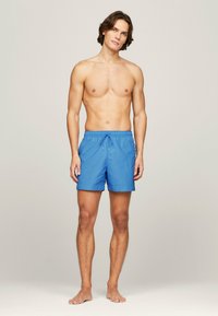 Costumi da bagno blu realizzati in tessuto leggero, con una cintura elastica e un cordoncino, e dettagli con logo laterale.