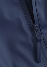Diepblauwe waterdichte stof met een gladde textuur, voorzien van een ritssluiting met een trekband en versterkte stiksels langs de randen.