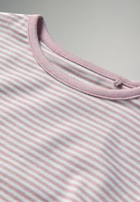 Šviesiai rožinė dryžuota marškinėliai su reljefiniu apykaklės kraštu. Minkšta, medvilninė medžiaga su pakaitomis baltais ir rožiniais dryžiais. Nėra matomų logotipų ar raštų.