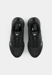 Musta urheilukengät, joissa on kuvioitu päällinen, pyöreä muoto ja nauhakiinnitys; varustettu hienovaraisella logolla ja heijastavilla yksityiskohdilla.