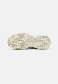 Talpa de pantof formată dintr-un material cauciucat texturat cu un model în zigzag. Culoare bej deschis cu un finisaj neted și o ușoară arcadă.