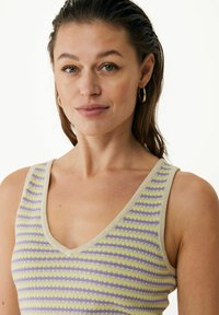 Randig ärmlös topp i beige med lavendel- och ljusgula ränder. Har en V-ringning och mjuk textur. Slät tyg.
