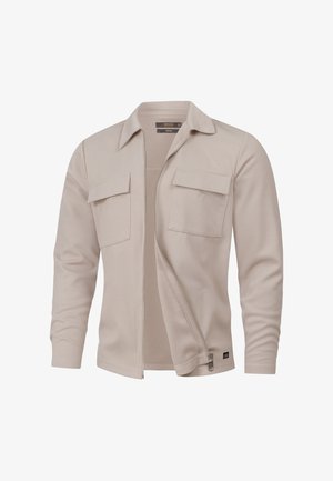 Beżowa kurtka na zamek z fakturowanej tkaniny, wyposażona w dwie kieszenie na piersi oraz kołnierz. Gładkie wykończenie z długimi rękawami.