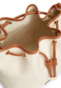 Τσαντάκι κάδου από δέρμα σε μπεζ και καφέ χρώμα με κλείσιμο κορδονιού, εξωτερικό με υφή, και εσωτερική θήκη με ετικέτα Tommy Hilfiger.