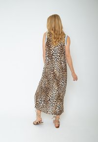 Maxikleid mit Leopardenmuster, lockerer Passform, ärmellosem Design und weichem Stoff. Mit einem fließenden Schnitt und einem seitlichen Schlitz für zusätzliche Bewegungsfreiheit.