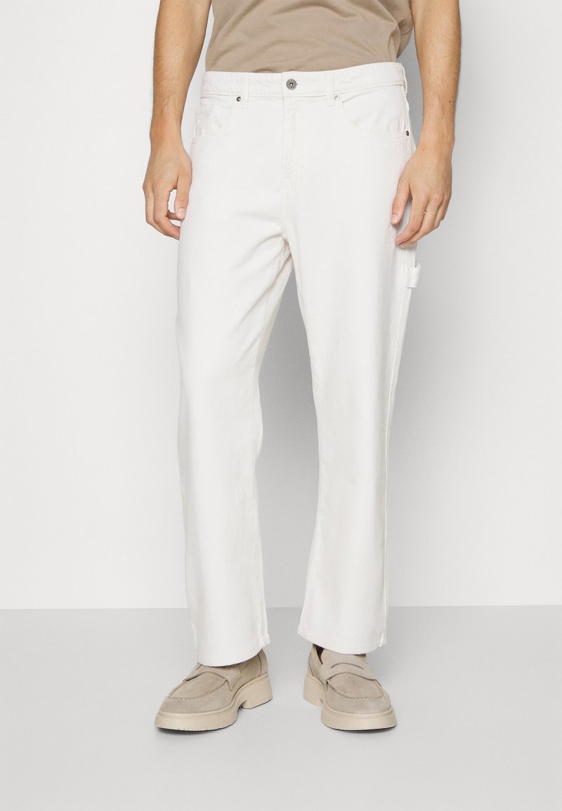 Pantalones de algodón blancos con un diseño de pierna recta, que cuentan con cierre de botón de metal, dos bolsillos laterales y un acabado texturizado sutil.