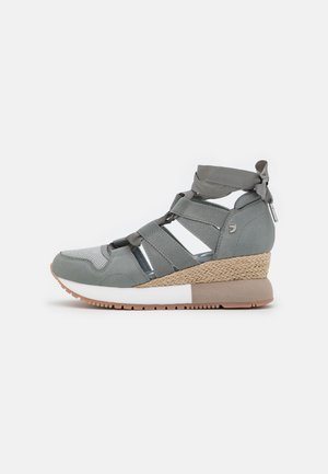 Szara sneaker na koturnie z krzyżującymi się paskami, wstążką przy kostce, plecioną wkładką i białą oraz beżową gumową podeszwą na białym tle.