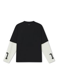 Schwarzes Kurzarmhemd übereinander getragen über weißen Langärmeln mit schwarzer Zahl "1" auf jedem Unterarm, von hinten vor weißem Hintergrund gezeigt.