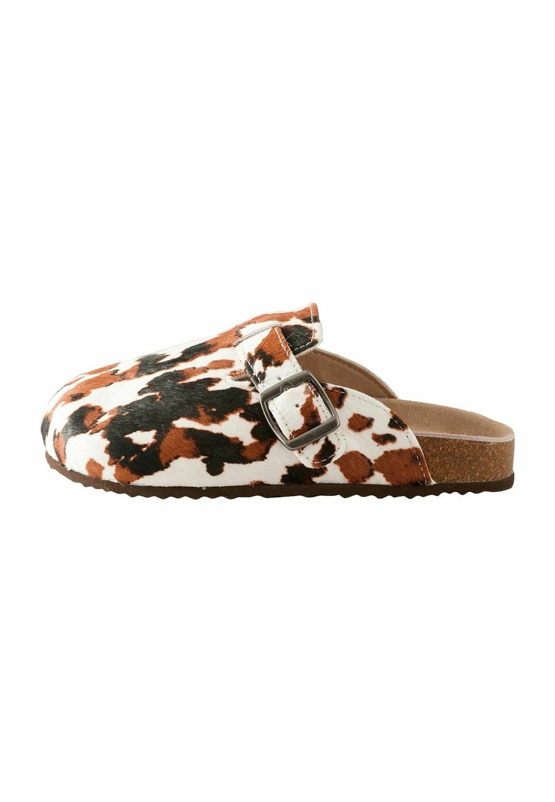Sandaler med koskinnsmönster i brunt, vitt och svart. Har ett enkelt rem med en metallspänne och en texturerad korksula.