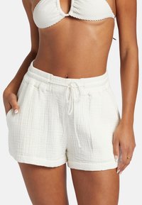 Białe bawełniane szorty o teksturowanym, pogniecionym wzorze; elastyczny pas z troczkiem; boczne kieszenie; zawinięty brzeg.