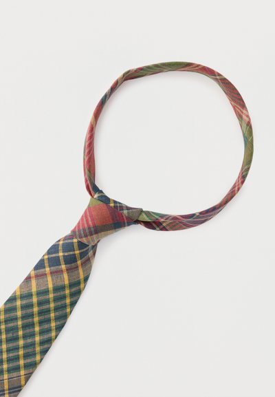 Καρό υφασμάτινη γραβάτα σε κόκκινους, πράσινους, μπλε και κίτρινους τόνους, δεμένη σε χαλαρό κόμπο πάνω σε λευκό φόντο.
