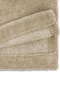 Beige, plush blanket made of soft, textured fabric. Edges are neatly sewn with a subtle sheen. Folded to display layers and texture.