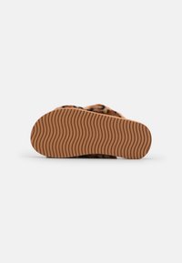 Leopard-print slide sandal with a fluffy texture, featuring a brown rubber sole with wave pattern and open back design for easy wear.