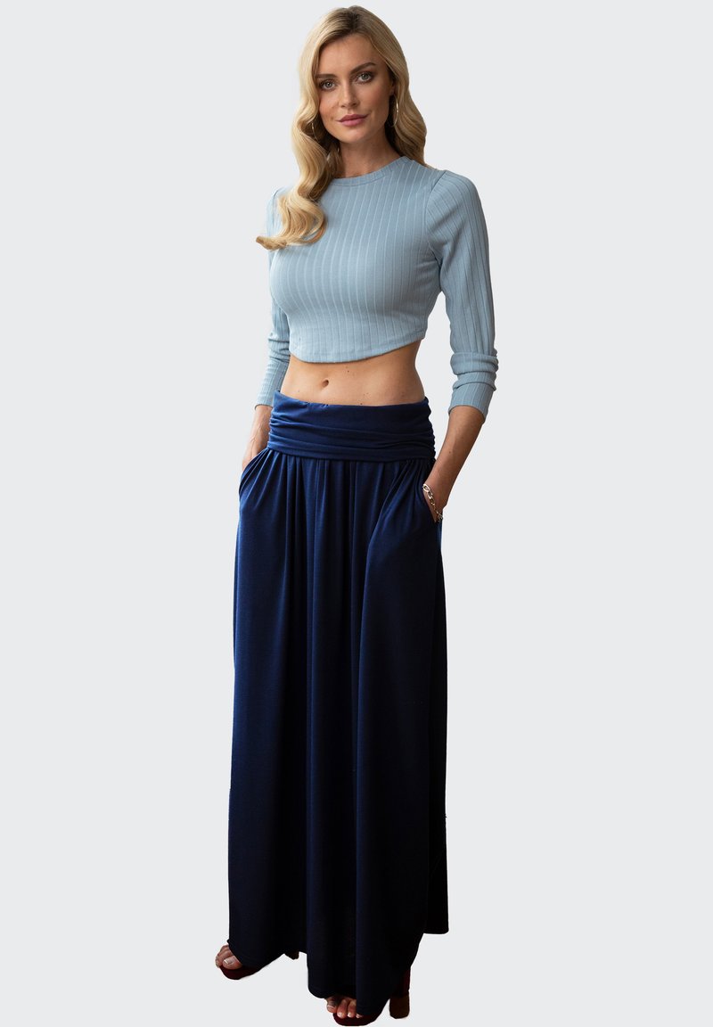 Lichtblauwe ribgebreide cropped sweater gecombineerd met een marineblauwe maxirok met een geraffineerde tailleband en zijzakken, met een soepele textuur.