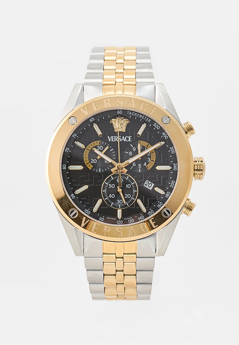 Montre chronographe Versace avec un cadran noir à motifs, une lunette dorée, un bracelet en acier inoxydable argenté et doré, et trois sous-cadrans pour les fonctions de chronométrage.