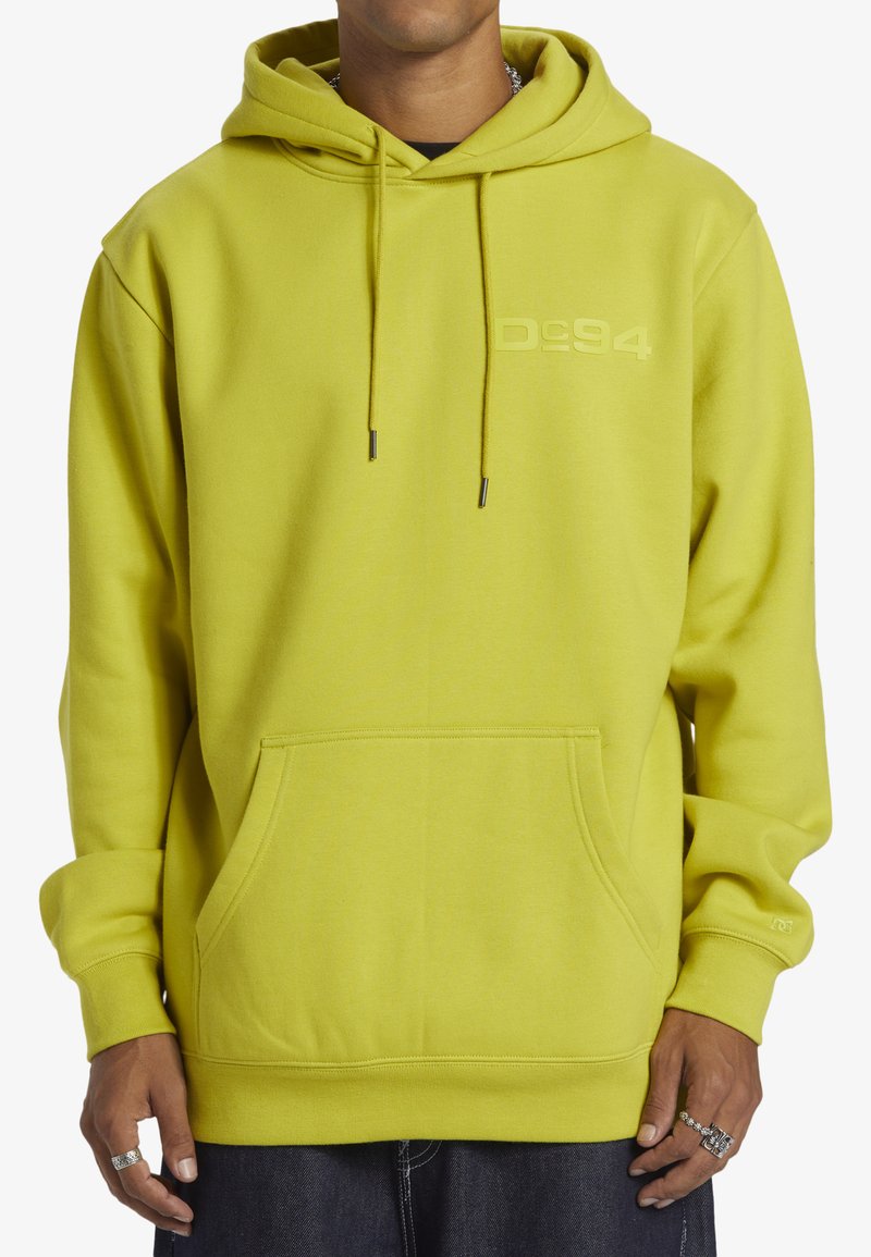 Ljusgul hoodie med en framficka, dragsko på huvan och logodetalj. Tillverkad av mjukt tyg med ribbade ärmslut och nederkant.