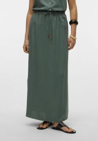 Longue jupe maxi verte en tissu léger avec une taille élastique et un cordon de serrage, dotée de fentes latérales et d'une coupe décontractée.