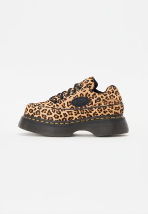 Platåsko med leopardmønstret stof, sorte snørebånd, tyk sort sål og gul syning.