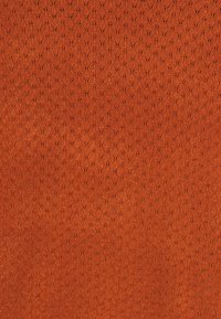 Tissu texturé de couleur orange riche présentant un motif répétitif de petites formes complexes. La texture douce et tissée améliore l'attrait visuel.