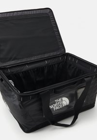 Black insulated tote bag with a zipper, featuring a mesh pocket and sturdy handles. Internal compartments for organization. полотно косметички.