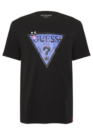 T-shirt en coton noir avec un graphique bleu en forme de triangle portant le mot "GUESS", des visages de dessins animés et le texte "WASHED JEANS" en caractères gras.