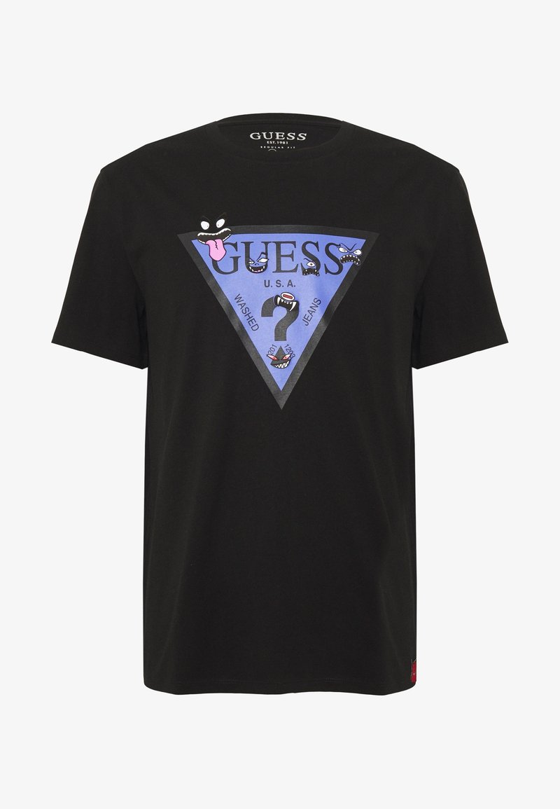 T-shirt en coton noir avec un graphique bleu en forme de triangle portant le mot "GUESS", des visages de dessins animés et le texte "WASHED JEANS" en caractères gras.