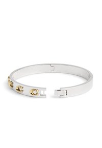 Bracciale a manichetta in argento con finitura liscia, caratterizzato da accenti decorativi in oro e un design minimalista. Si apre con un meccanismo a gancio.