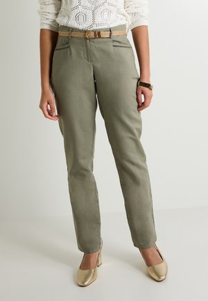 Pantalones verde oliva con una forma ajustada, que cuentan con un cinturón tejido beige y bolsillos frontales. Combinados con unos zapatos de tacón alto en oro claro.