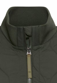 Oliwkowa pikowana kurtka z prążkowanym stójkowym kołnierzem i przednim zamkiem błyskawicznym z materiałowym uchwytem.