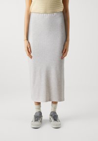 Lys grå, ribbet midi-skjørt med elastisk midjebånd, kombinert med grå sneakers og kremfargede sokker. Glatt tekstur, figursydd design.