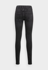 Vaqueros ajustados negros de denim, con una cintura alta, cinco bolsillos y una textura suave con un desvanecimiento mínimo.