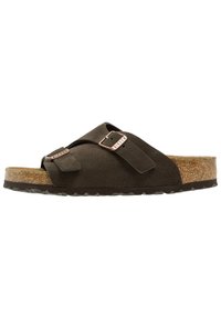 Dark brown suede slide sandal with two adjustable straps, metal buckles, and a cork footbed with black rubber sole.