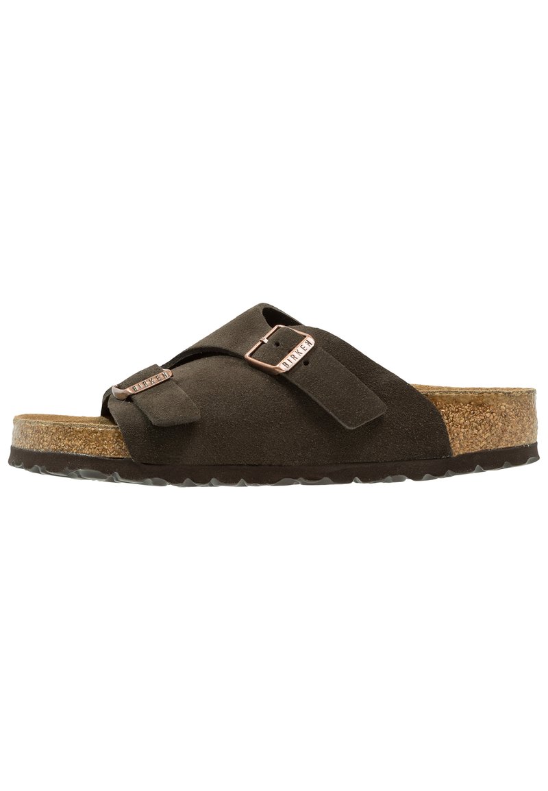 Dark brown suede slide sandal with two adjustable straps, metal buckles, and a cork footbed with black rubber sole.