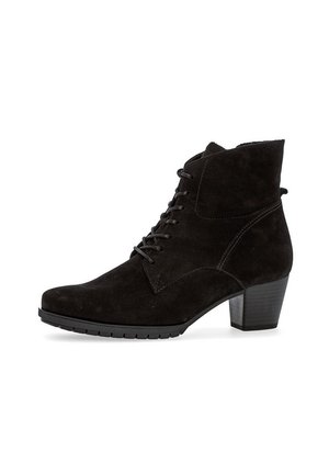 Bottine noire en daim avec un laçage à l'avant, des coutures sur les côtés et un talon bloc de hauteur intermédiaire empilé, sur fond blanc.