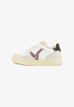 White sneaker with textured cream accents and a animal print design. Features a padded collar, round toe, and rubber sole. Brand logo on heel.
