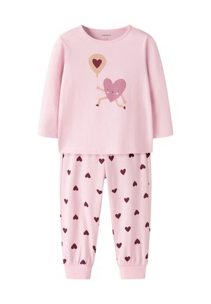 Haut rose à manches longues avec un cœur souriant tenant un ballon, associé à un pantalon rose avec un motif de cœur foncé.