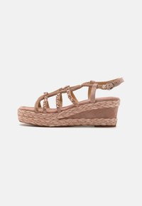 Hæl-sandal i myk rosa semsket skinn. Den har en flettet jute-såle, kryssende stropper, perle-detaller og ankelrem med justerbar spenne.