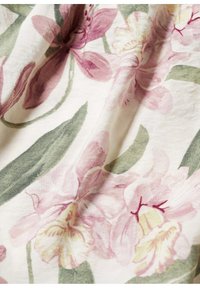 Materiał w kwiaty z jasnoróżowymi i kremowymi kwiatami oraz zielonymi liśćmi, wykonany z miękkiego, teksturowanego materiału o subtelnym połysku.