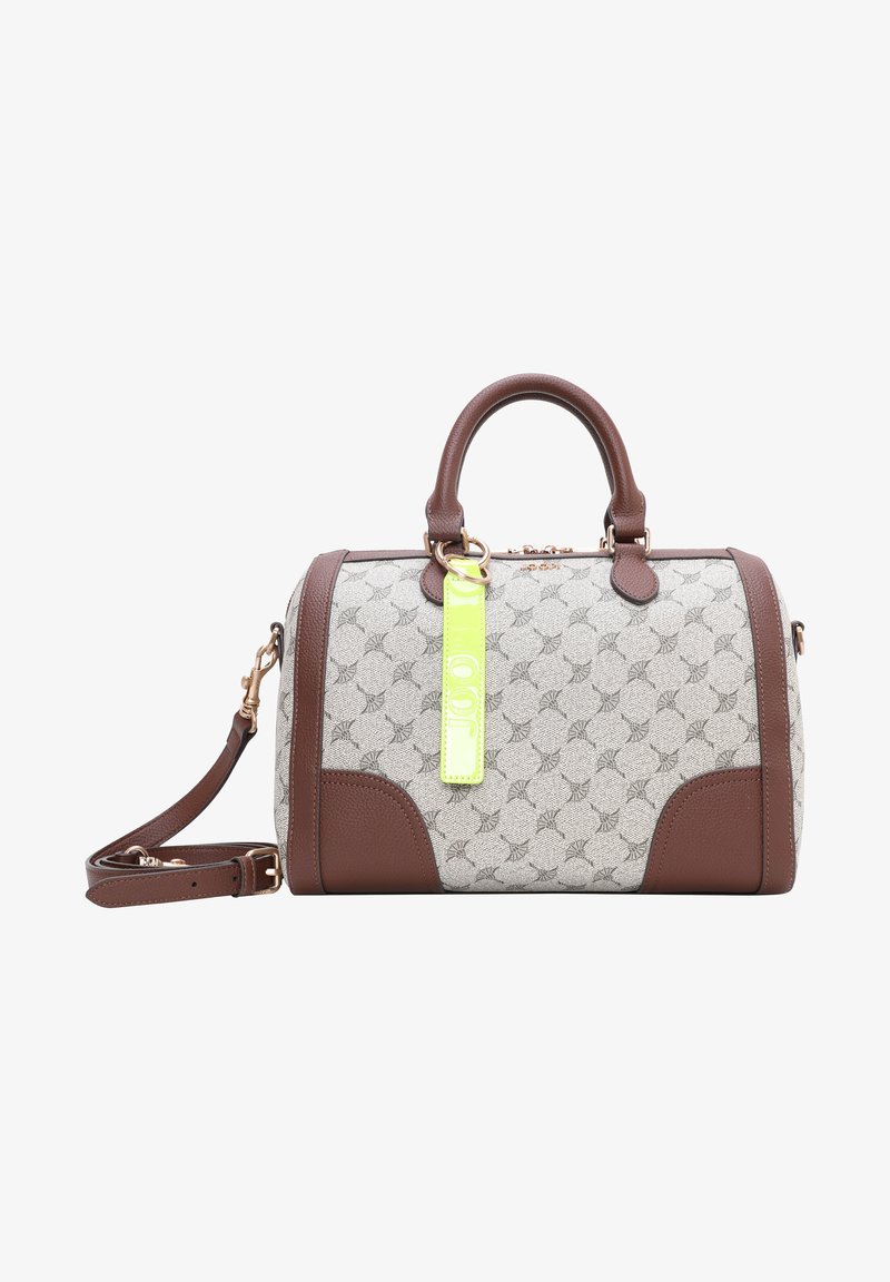 Sac à main beige et marron à motifs, avec deux poignées, une bandoulière amovible, et une étiquette jaune fluo attachée à la poignée.