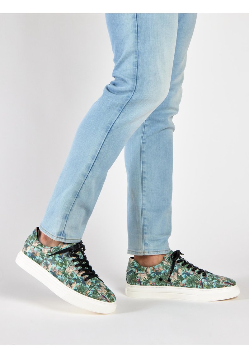 Floral-patterned sneakers with a black lace-up design, lightweight material, and white rubber sole, paired with light blue jeans.